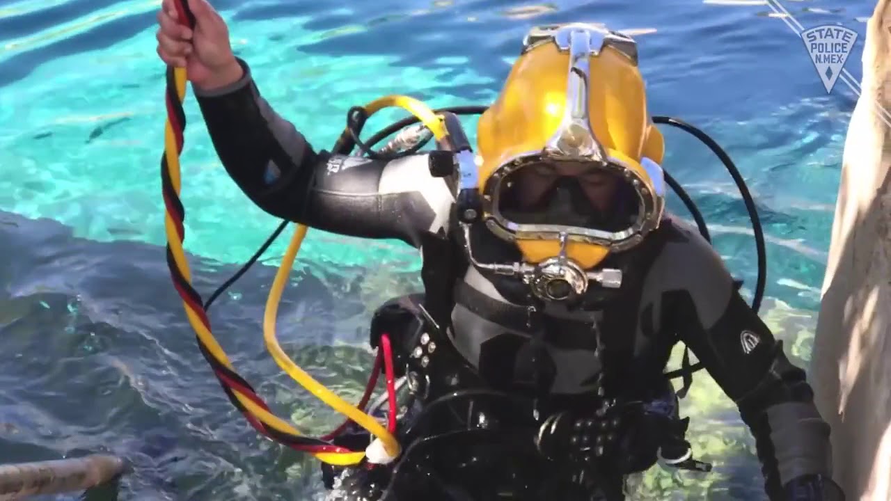 Person wearing scuba gear emerges from pool