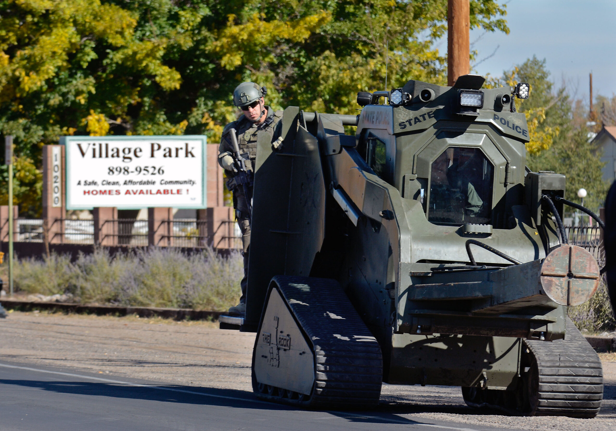 Officer riding and operating heavy machinery on city street near park